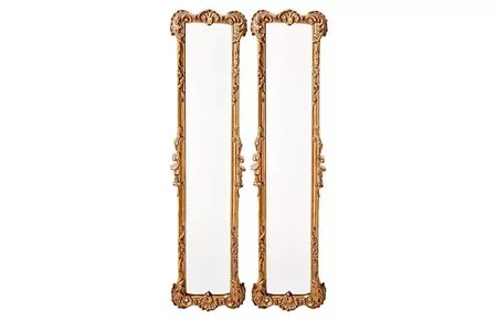 A pair of skinny, eclectic, gold-leaf oversized mirrors.